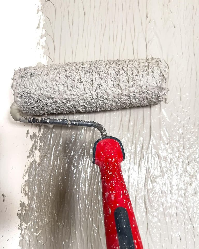 Nakładanie jasnoszarej gładzi Megaron wałkiem do gładzi.